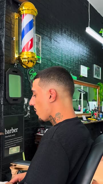 Taper fade under the gold barber pole at Big's Space